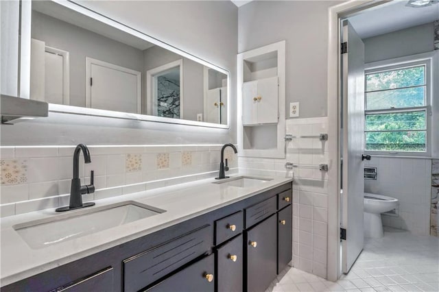 1480 E 76th Ter, Kansas City, MO 64131 - full bath with double vanity, tile walls, tile patterned floors, and a wainscoted wall