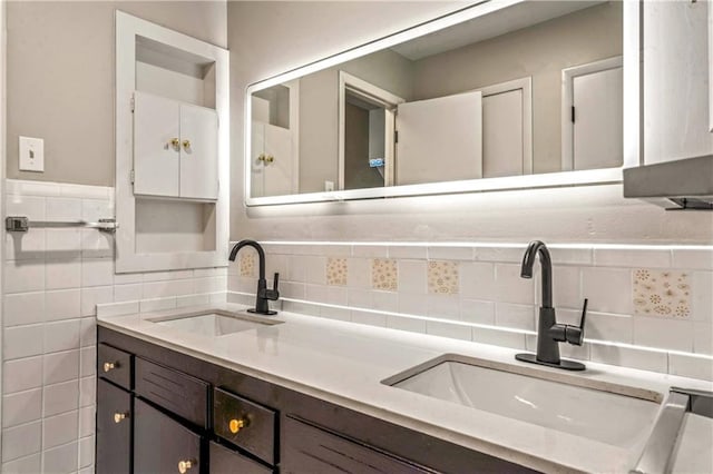 1480 E 76th Ter, Kansas City, MO 64131 - bathroom with double vanity, tasteful backsplash, and tile walls