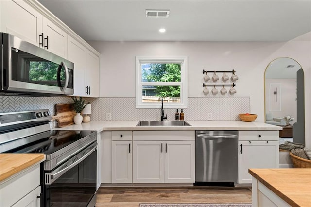 521 E Bird St, Hamilton, MO 64644 - kitchen featuring appliances with stainless steel finishes, wooden counters, white cabinetry, tasteful backsplash, and recessed lighting
