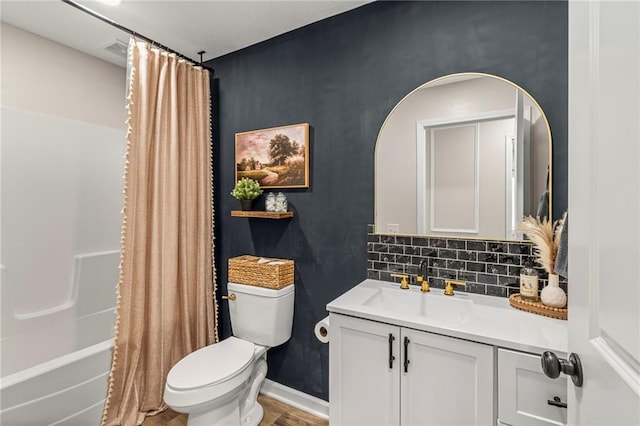 521 E Bird St, Hamilton, MO 64644 - full bathroom featuring vanity, wood finished floors, shower / bathtub combination with curtain, and tasteful backsplash