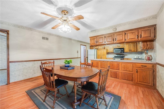 705 Ozark Short Line, Odessa, MO 64076 - dining area with light wood-style floors, ceiling fan, and a textured ceiling