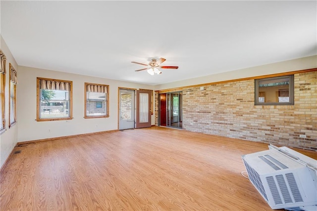 705 Ozark Short Line, Odessa, MO 64076 - unfurnished living room featuring brick wall, light wood-type flooring, and a ceiling fan