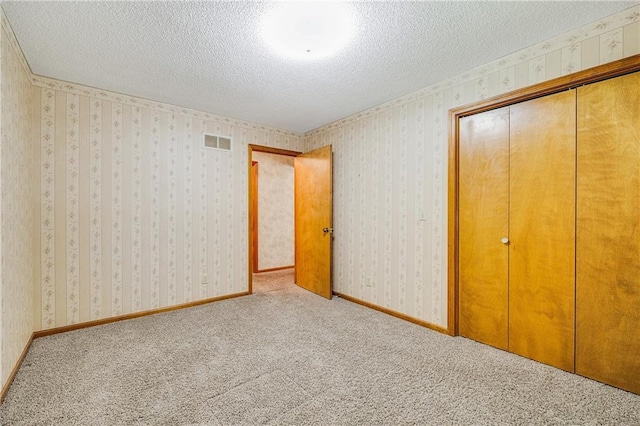 705 Ozark Short Line, Odessa, MO 64076 - unfurnished bedroom with a textured ceiling, carpet flooring, a closet, and wallpapered walls