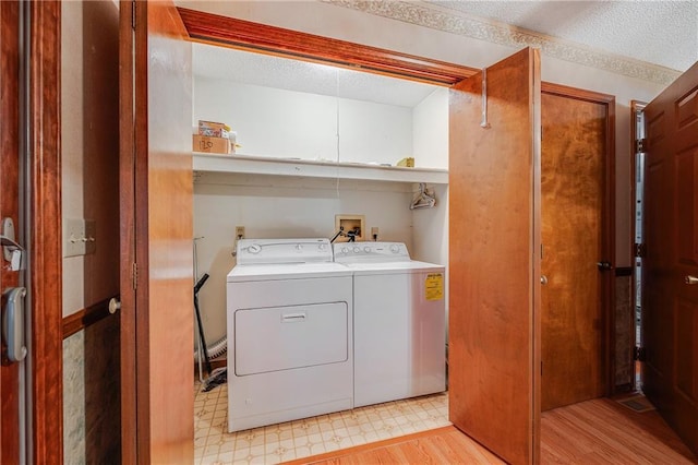 705 Ozark Short Line, Odessa, MO 64076 - laundry room featuring washing machine and dryer, a textured ceiling, and light wood-type flooring