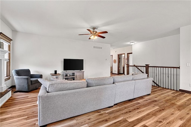 1658 Davis Cir, Eudora, KS 66025 - living room featuring a ceiling fan, light wood-style flooring, and a fireplace