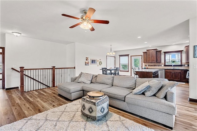 1658 Davis Cir, Eudora, KS 66025 - living room with light wood-style flooring, ceiling fan, a chandelier, and recessed lighting