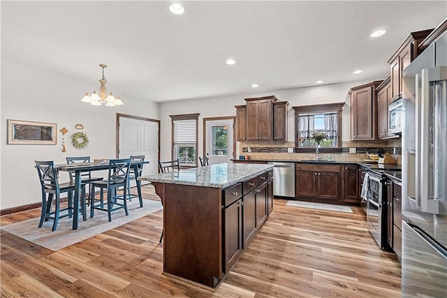 1658 Davis Cir, Eudora, KS 66025 - kitchen with appliances with stainless steel finishes, light wood finished floors, dark brown cabinets, backsplash, and recessed lighting