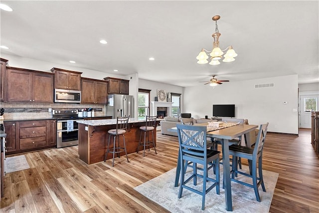 1658 Davis Cir, Eudora, KS 66025 - kitchen featuring stainless steel appliances, a chandelier, light wood-type flooring, ceiling fan, and recessed lighting
