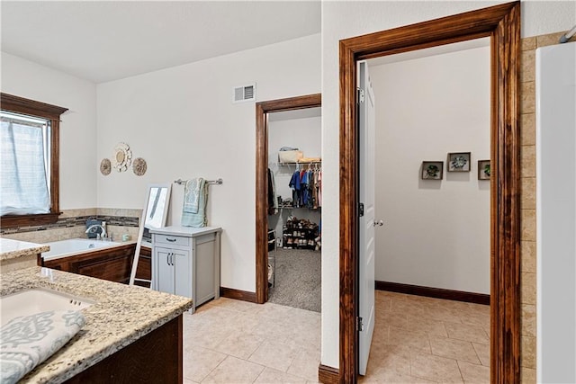 1658 Davis Cir, Eudora, KS 66025 - bathroom with a garden tub, vanity, a walk in closet, and tile patterned floors
