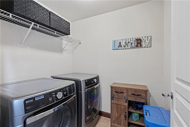 1658 Davis Cir, Eudora, KS 66025 - laundry area with washer and clothes dryer, a textured ceiling, and light tile patterned flooring