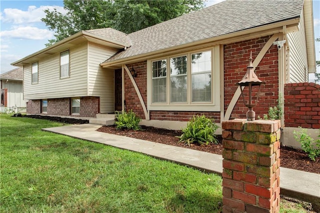 1004 SW Twilight Ln, Blue Springs, MO 64015 - split level home with roof with shingles, brick siding, and a front yard