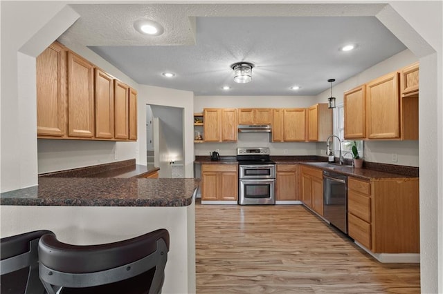 1004 SW Twilight Ln, Blue Springs, MO 64015 - kitchen with stainless steel appliances, a peninsula, under cabinet range hood, dark countertops, and open shelves
