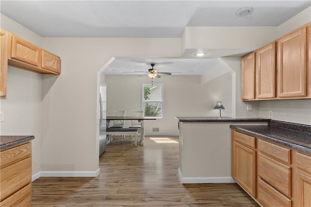 1004 SW Twilight Ln, Blue Springs, MO 64015 - kitchen featuring stainless steel refrigerator, wood finished floors, a ceiling fan, light brown cabinets, and a peninsula