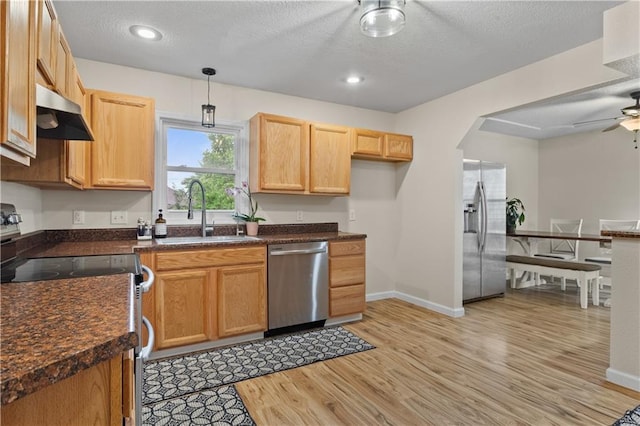 1004 SW Twilight Ln, Blue Springs, MO 64015 - kitchen featuring stainless steel appliances, light wood-type flooring, ceiling fan, dark countertops, and a textured ceiling