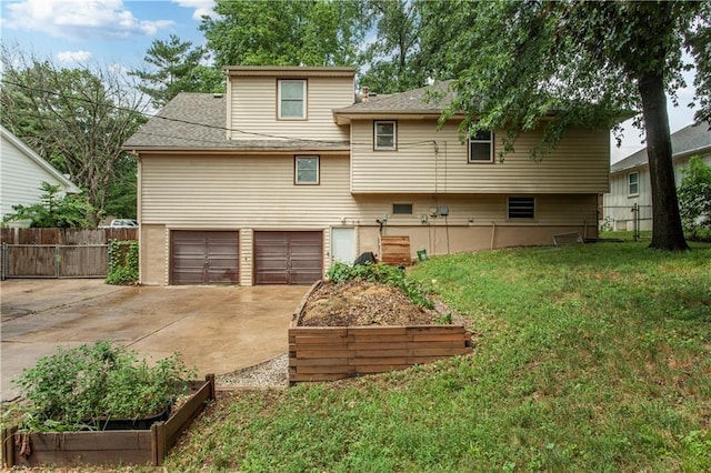 1004 SW Twilight Ln, Blue Springs, MO 64015 - back of property featuring concrete driveway, an attached garage, a garden, and roof with shingles