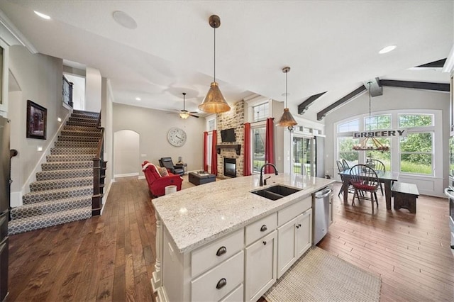 9158 W 178th Ter, Overland Park, KS 66013 - kitchen featuring a stone fireplace, dishwasher, a ceiling fan, dark wood finished floors, and white cabinetry