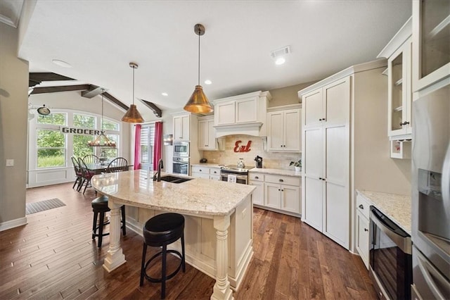 9158 W 178th Ter, Overland Park, KS 66013 - kitchen featuring stainless steel appliances, decorative backsplash, dark wood-style floors, a breakfast bar, and an island with sink