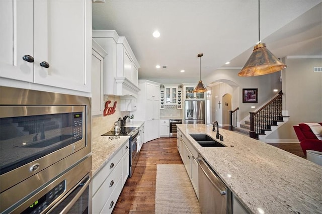 9158 W 178th Ter, Overland Park, KS 66013 - kitchen featuring appliances with stainless steel finishes, arched walkways, recessed lighting, light stone counters, and backsplash