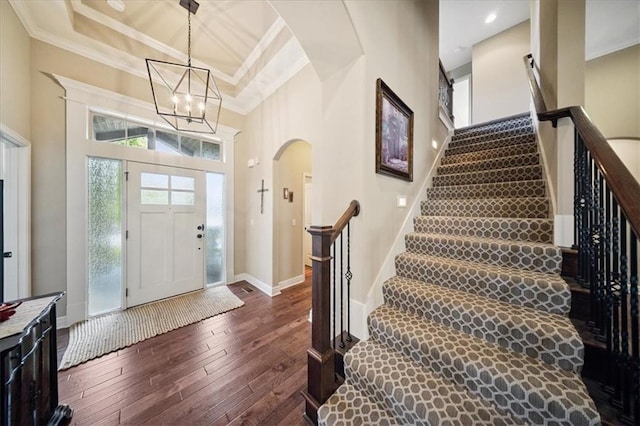 9158 W 178th Ter, Overland Park, KS 66013 - entrance foyer with dark wood finished floors, a towering ceiling, stairs, arched walkways, and ornamental molding