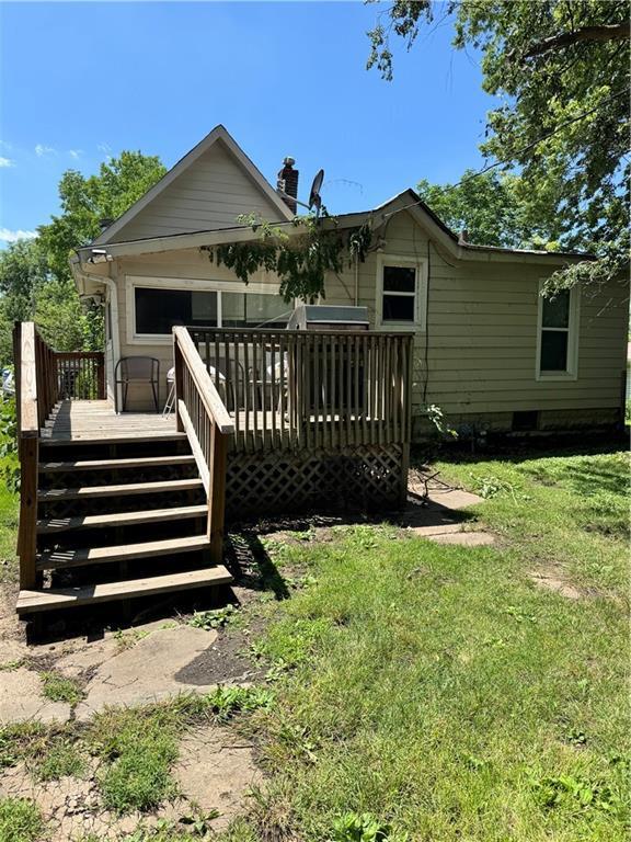 406 S 2nd St, Odessa, MO 64076 - back of property featuring stairs, a lawn, and a deck