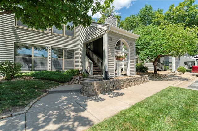 8858 W 106th Ter, Overland Park, KS 66212 - view of front of house with a chimney, stairs, and a front yard