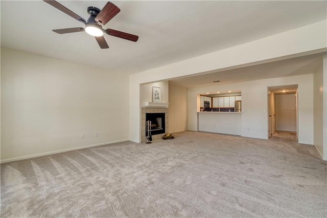 8858 W 106th Ter, Overland Park, KS 66212 - unfurnished living room featuring light carpet, ceiling fan, and a tiled fireplace
