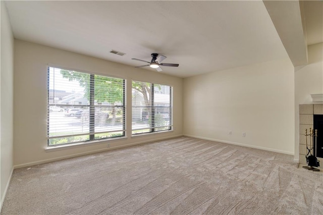 8858 W 106th Ter, Overland Park, KS 66212 - unfurnished living room featuring ceiling fan, healthy amount of natural light, light colored carpet, and a tiled fireplace