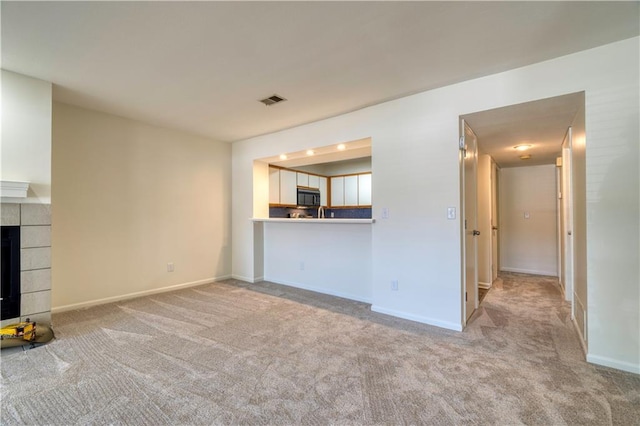 8858 W 106th Ter, Overland Park, KS 66212 - unfurnished living room with carpet flooring and a tiled fireplace