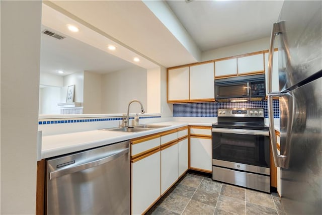 8858 W 106th Ter, Overland Park, KS 66212 - kitchen with stainless steel appliances, light countertops, recessed lighting, backsplash, and white cabinetry