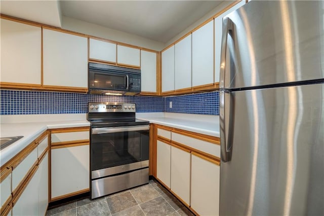8858 W 106th Ter, Overland Park, KS 66212 - kitchen featuring appliances with stainless steel finishes, light countertops, decorative backsplash, and white cabinetry