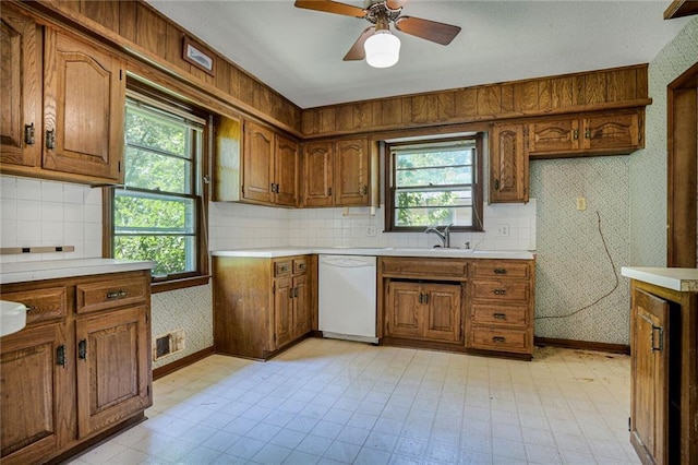 619 E 109th Ter, Kansas City, MO 64131 - kitchen featuring dishwasher, brown cabinets, and plenty of natural light