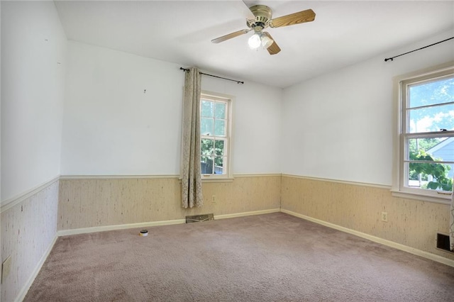 619 E 109th Ter, Kansas City, MO 64131 - carpeted empty room with a wainscoted wall and ceiling fan