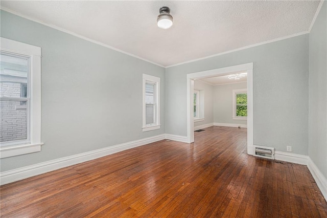 3344 Chestnut Ave, Kansas City, MO 64128 - empty room featuring hardwood / wood-style flooring, ornamental molding, and a textured ceiling