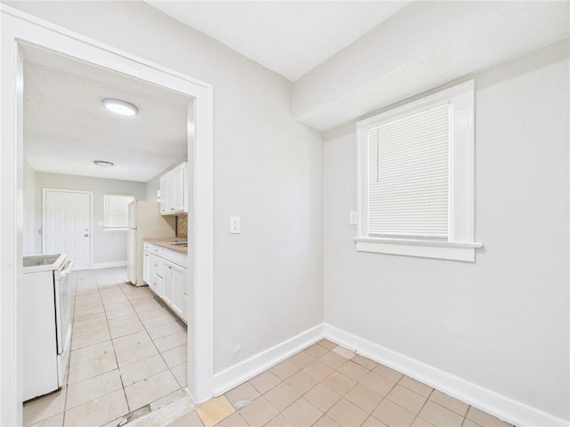 3904 Bales Ave, Kansas City, MO 64130 - unfurnished dining area with baseboards and light tile patterned floors