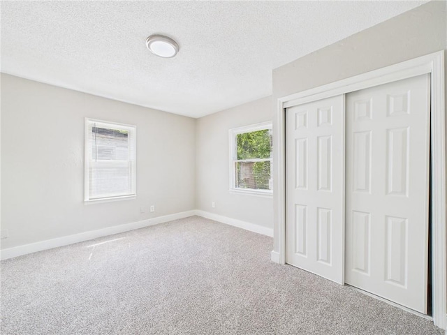 3904 Bales Ave, Kansas City, MO 64130 - unfurnished bedroom featuring carpet flooring, a textured ceiling, and a closet