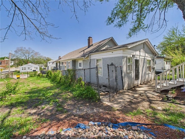 3904 Bales Ave, Kansas City, MO 64130 - view of home's exterior featuring a chimney and stucco siding