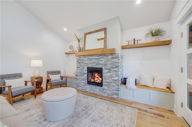 48 M St, Lake Lotawana, MO 64086 - living area featuring wood finished floors, a stone fireplace, vaulted ceiling, and recessed lighting