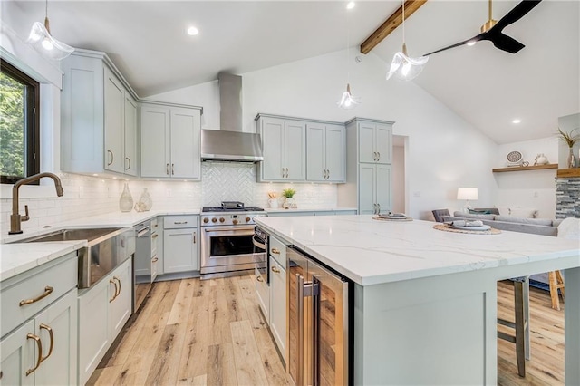 48 M St, Lake Lotawana, MO 64086 - kitchen featuring appliances with stainless steel finishes, wall chimney range hood, wine cooler, gray cabinets, and light wood-type flooring