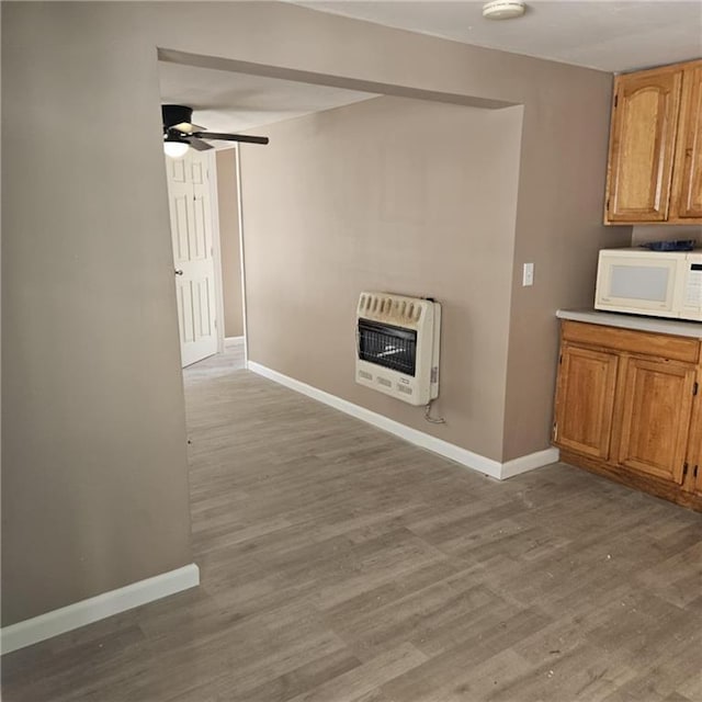 11601 E US Highway 24th Rd, Independence, MO 64054 - unfurnished living room featuring heating unit, a ceiling fan, and light wood-style floors