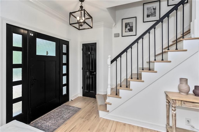 11245 S Penrose St, Olathe, KS 66061 - foyer entrance with wood finished floors, crown molding, a chandelier, and stairway