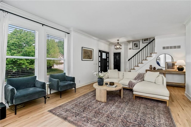 11245 S Penrose St, Olathe, KS 66061 - living area featuring crown molding, light wood-type flooring, and stairway