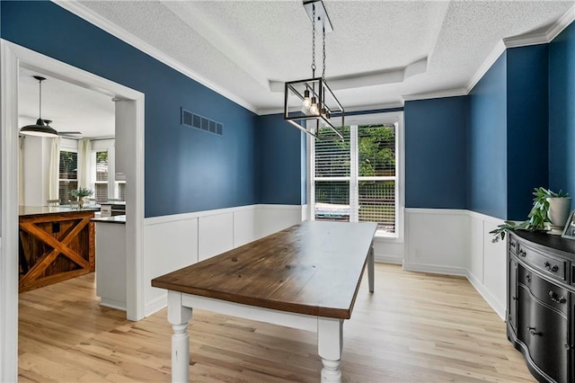 11245 S Penrose St, Olathe, KS 66061 - dining area with a textured ceiling, plenty of natural light, wainscoting, light wood-style floors, and a chandelier