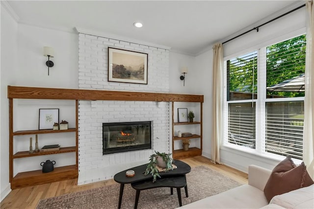 11245 S Penrose St, Olathe, KS 66061 - living room with crown molding, wood finished floors, a brick fireplace, and recessed lighting