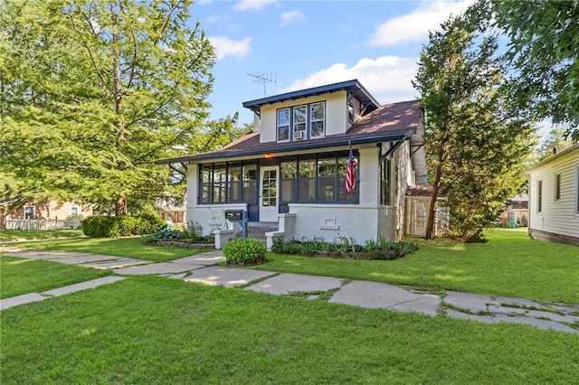309 E Miami St, Paola, KS 66071 - view of front of property featuring stucco siding, a front lawn, a sunroom, and a shingled roof