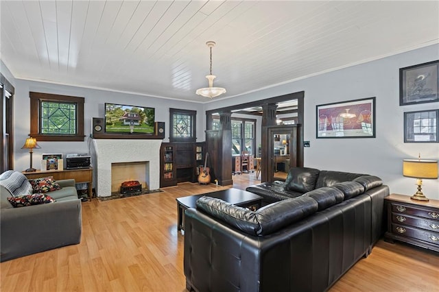 309 E Miami St, Paola, KS 66071 - living area featuring a fireplace with flush hearth, ornate columns, light wood-style flooring, wooden ceiling, and ornamental molding