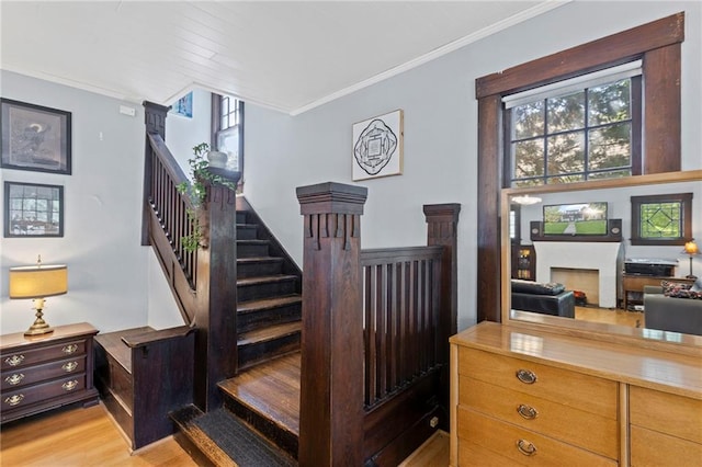309 E Miami St, Paola, KS 66071 - stairs featuring wood finished floors, crown molding, plenty of natural light, and a fireplace