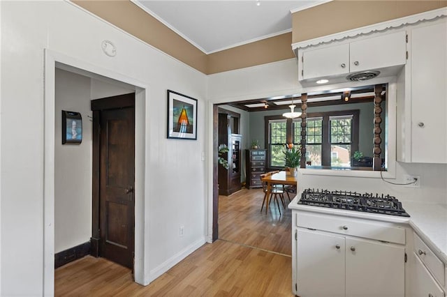 309 E Miami St, Paola, KS 66071 - kitchen with light wood-style floors, light countertops, crown molding, white cabinetry, and black gas stovetop