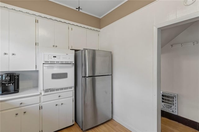 309 E Miami St, Paola, KS 66071 - kitchen with freestanding refrigerator, oven, heating unit, light wood-style floors, and light countertops