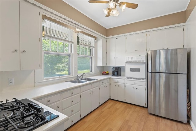 309 E Miami St, Paola, KS 66071 - kitchen featuring freestanding refrigerator, oven, light wood-type flooring, black gas stovetop, and light countertops
