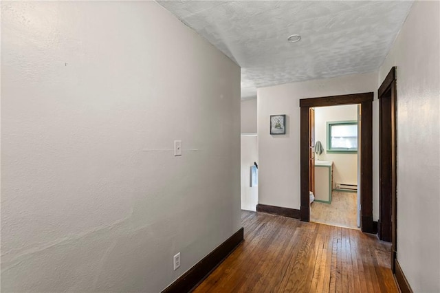 309 E Miami St, Paola, KS 66071 - hallway with hardwood / wood-style floors and baseboard heating